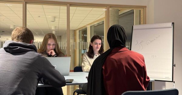 vier studenten aan een bureau